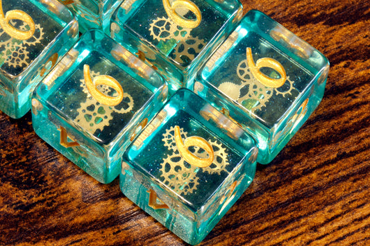 Dés D6 Rouages Éthérés – Couche scintillante bleu-vert avec petites inclusions d'engrenages dorés