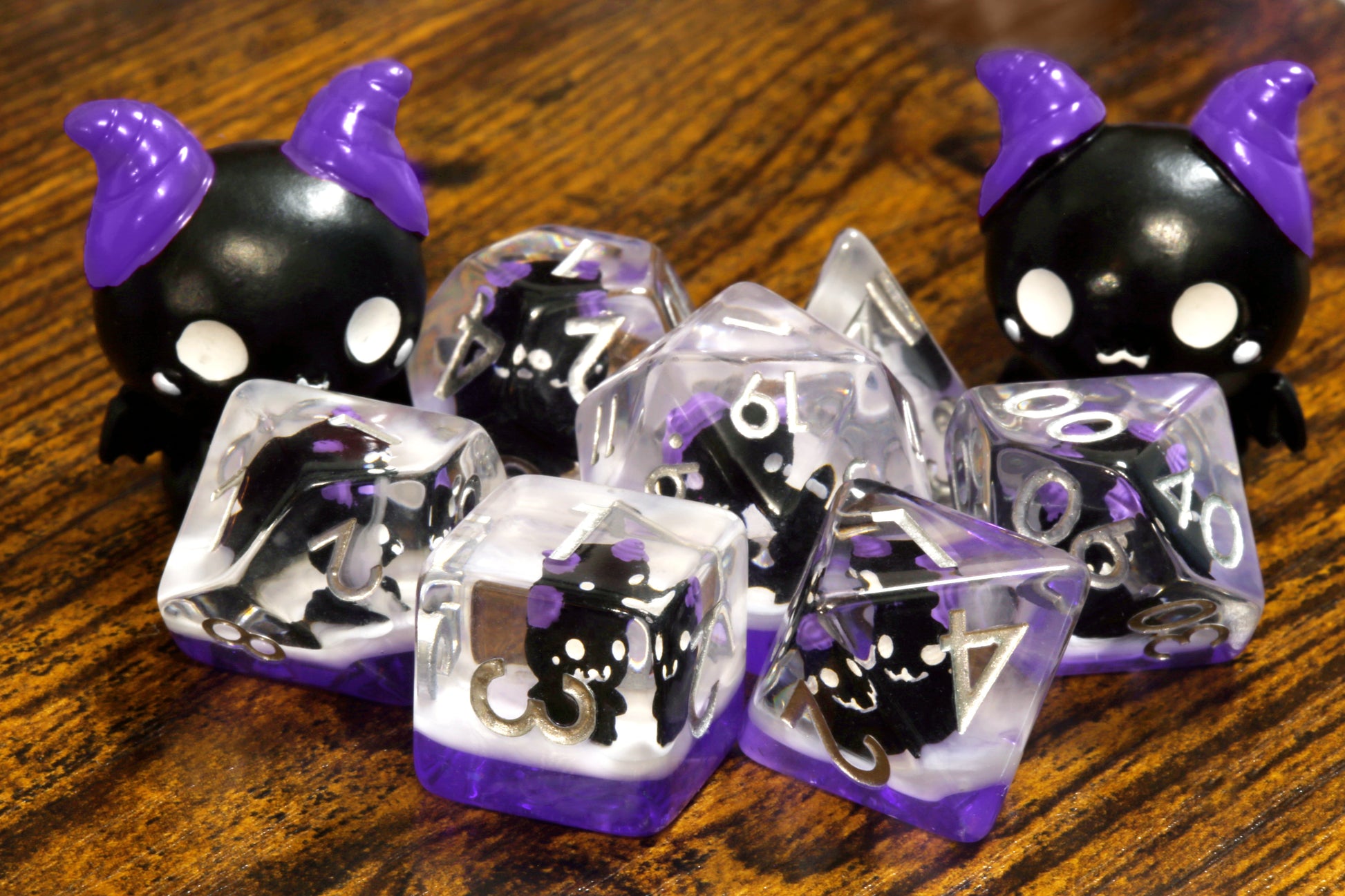 Cats of doom dice set - Dice set with winged cats on an purple layer - The Wizard's Vault
